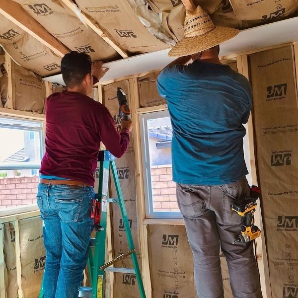 Two Squared Construction employees working together during a room remodel.