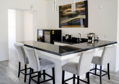 A black marble bar with white accents that was built for a bar remodeling job by Squared Construction.