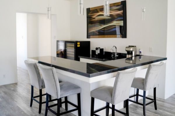 A new bar with a black marble countertop that has been added during a remodel
