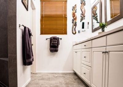 A newly remodeled bathroom with new vinyl flooring and added cabinet and counter space.
