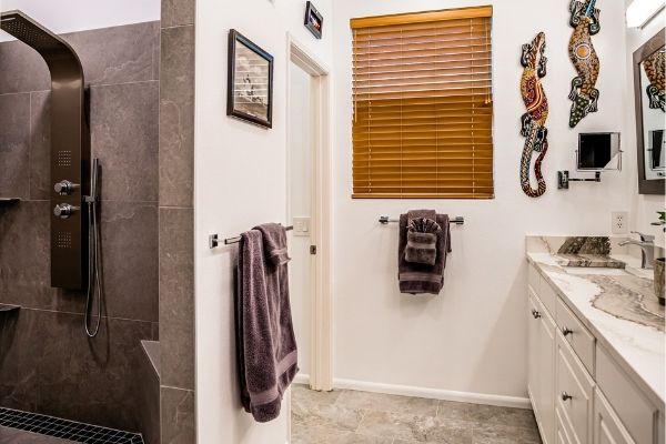 A newly completed bathroom remodel featuring new cabinets, flooring, and shower tiles.