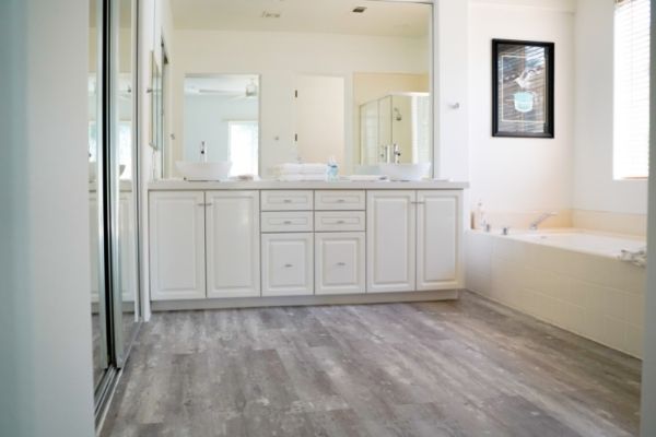 A bathroom with newly installed wood like vinyl flooring.