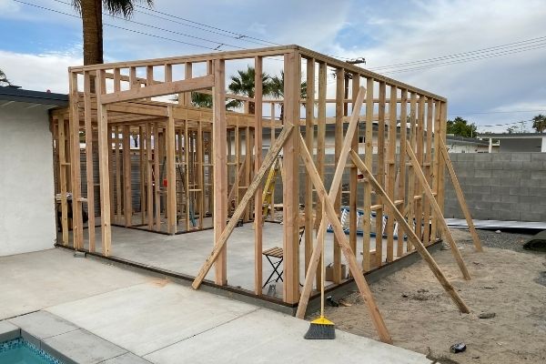 The wooden frame of a bedroom addition in the process of being constructed.