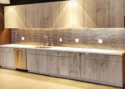 A kitchenette with a unique metal backsplash that has been added during a kitchen remodel