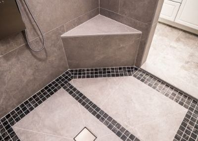 A remodeled shower with new tiles and built in seating